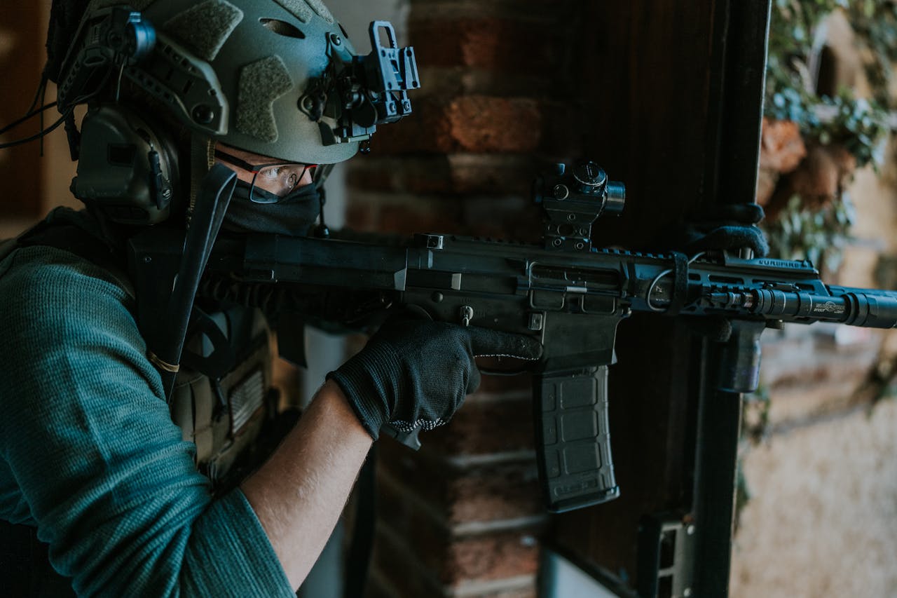 A special forces soldier equipped with tactical gear and weapon, engaging in a mission indoors.